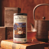 Organic Assam Breakfast Tea with cup of tea, books, and a kettle