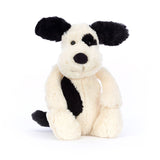 Black and Cream Puppy Stuffed Animal on a white background