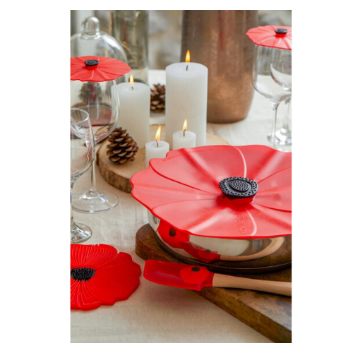 Charles Viancin Poppy Lid on top of a pan on a set table with glasses and poppy glass covers