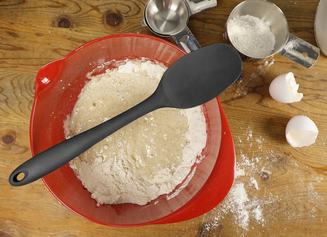 Blue silicone spoon on top of bowl of ingredients