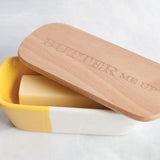 Talisman Ceramic Butter Dish with Wood Lid that reads Butter Me Up with butter in it