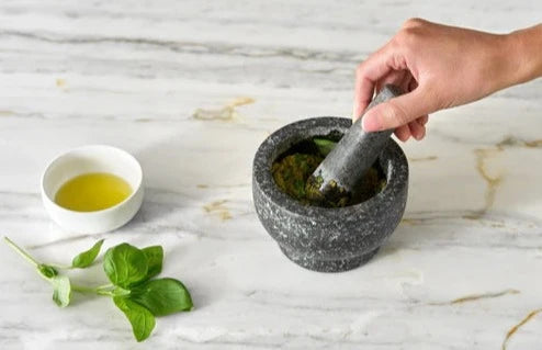 Zyliss Cole & Mason Mortar & Pestle with herbs and oil making salad dressing