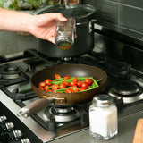 Salt and Pepper spicing on veggies on stove