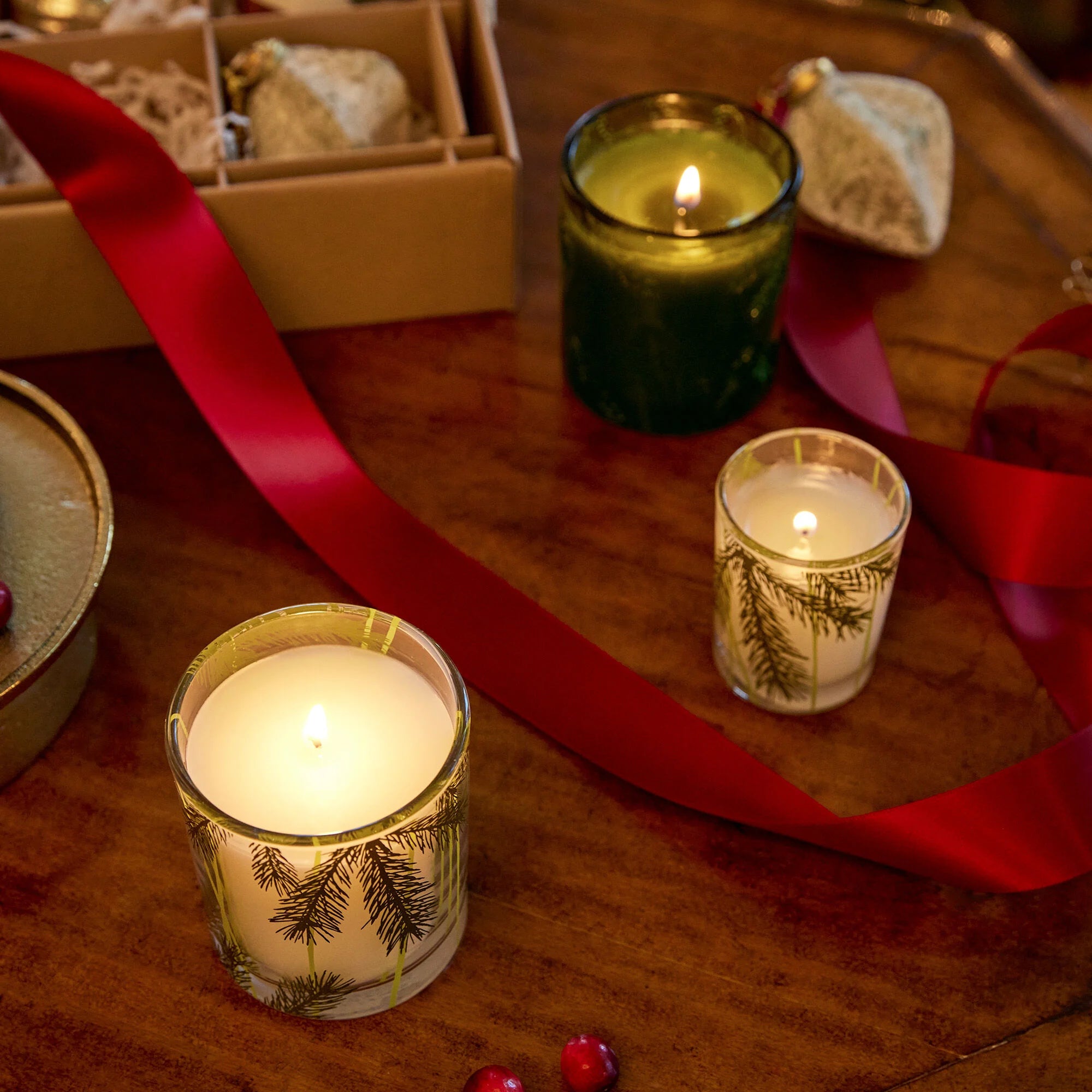 Thymes Frasier Fir Votives lit on table with decorations