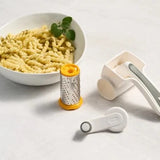 Zyliss Classic Cheese Grater with parts in front of bowl of pasta