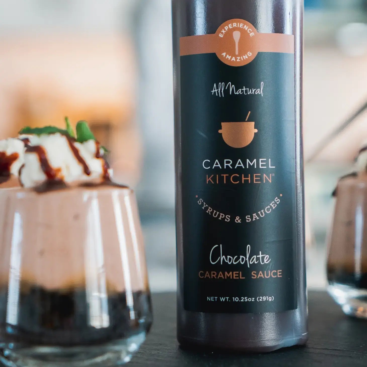 Caramel Kitchen Sauce- Chocolate Flavor with dessert next to it.