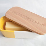 Talisman Ceramic Butter Dish with Wood Lid that reads Butter Me Up with butter in it