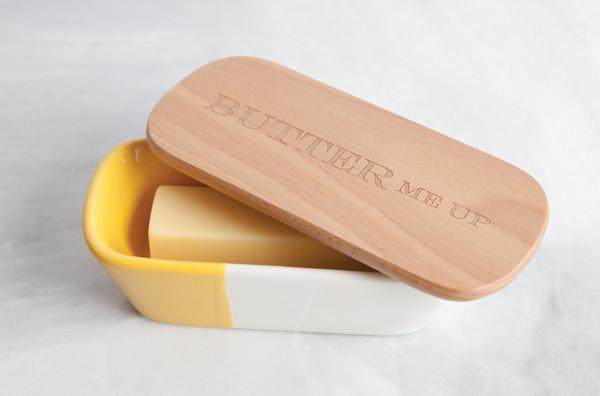 Talisman Ceramic Butter Dish with Wood Lid that reads Butter Me Up with butter in it