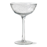 Clear glass cocktail glass with bubble texture on a white background