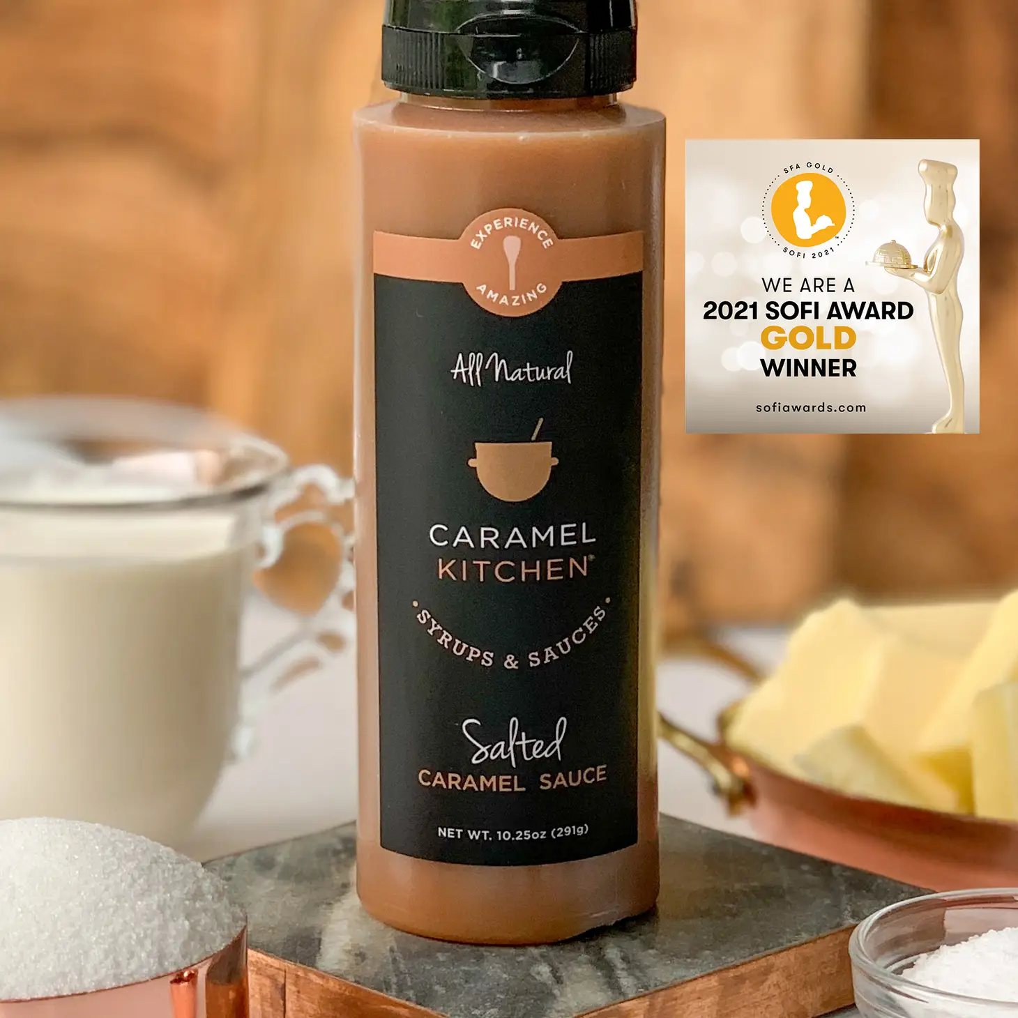 Caramel Kitchen Sauce-Salted Caramel Flavor with a glass of milk and butter in the background.  2021 SOFI  Gold Award Winner