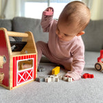 Child playing with Begin Again Barnyard Shape Sorter