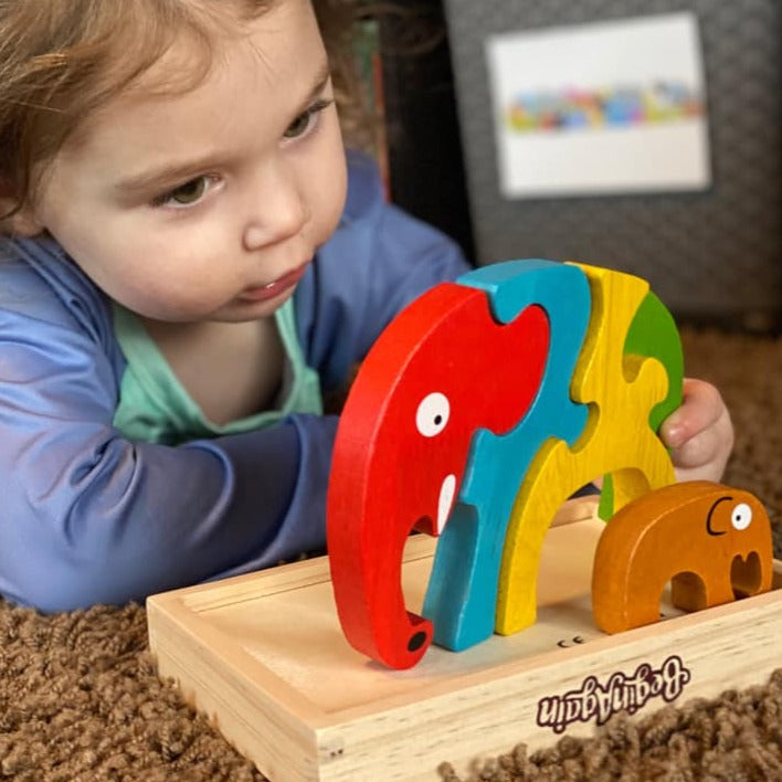 Child playing with the Elephants. Storage box turned upside down to use as a platform for the elephants to stand on