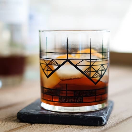 Vital Industries glass with geometric design of a mountain on it.