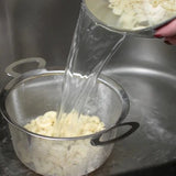 RSVP Wide Rim Mesh Basket filled with pasta being strained with water