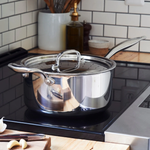 Stainless steel pot on a stove with a kitchen background