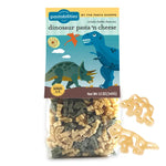 Packaged dinosaur pasta with cheese mix and dinosaur-shaped cutters on a white background