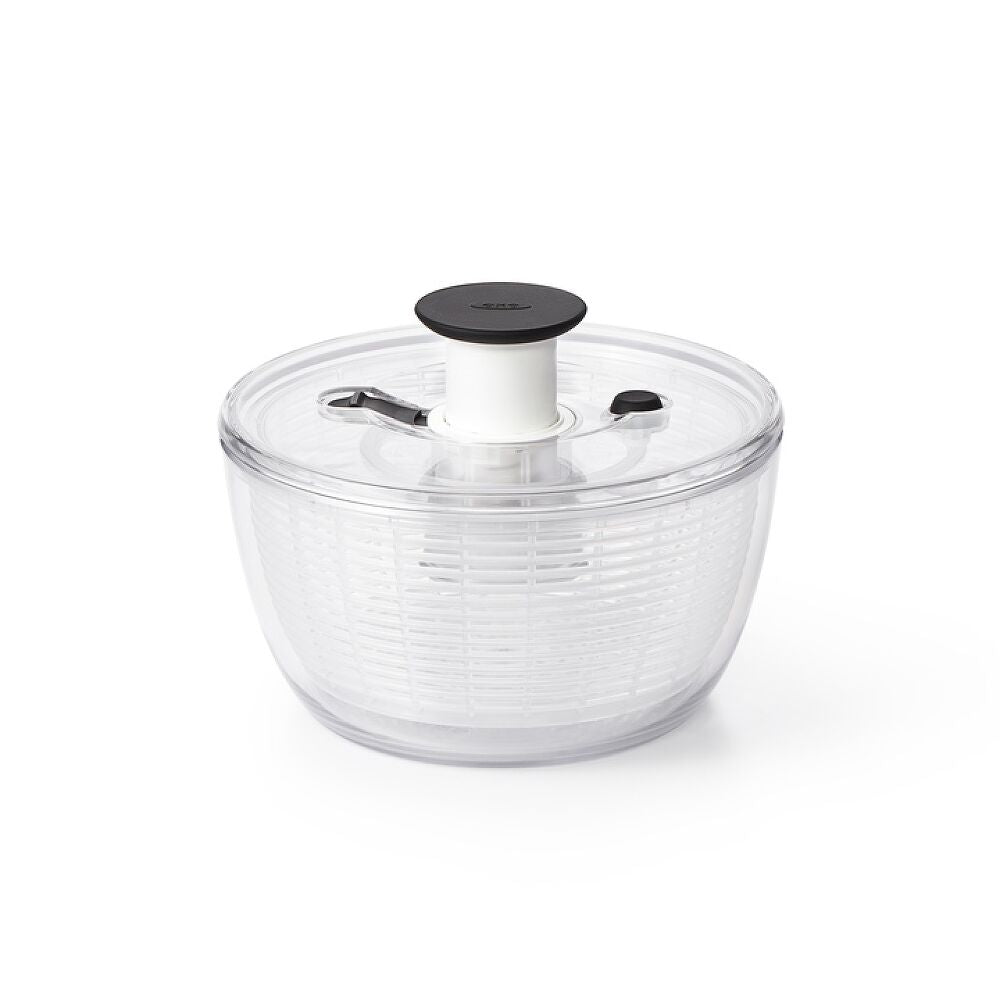 Clear salad spinner with black lid on a white background