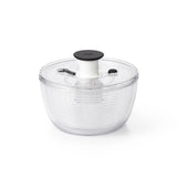 Clear salad spinner with black lid on a white background