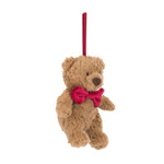 Plush teddy bear with a red bow tie on a white background hanging at an angle