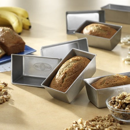 Set of four mini loaf pans with bread in them