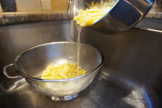 Pasta being strained through colander